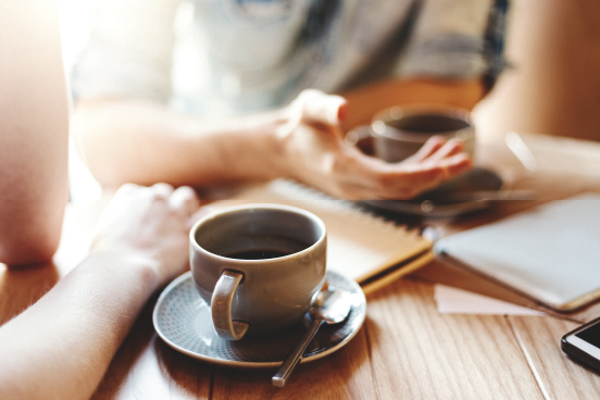 オフィスで同僚とコーヒーを楽しむイメージ写真