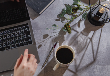 仕事中にコーヒーを飲むイメージ写真